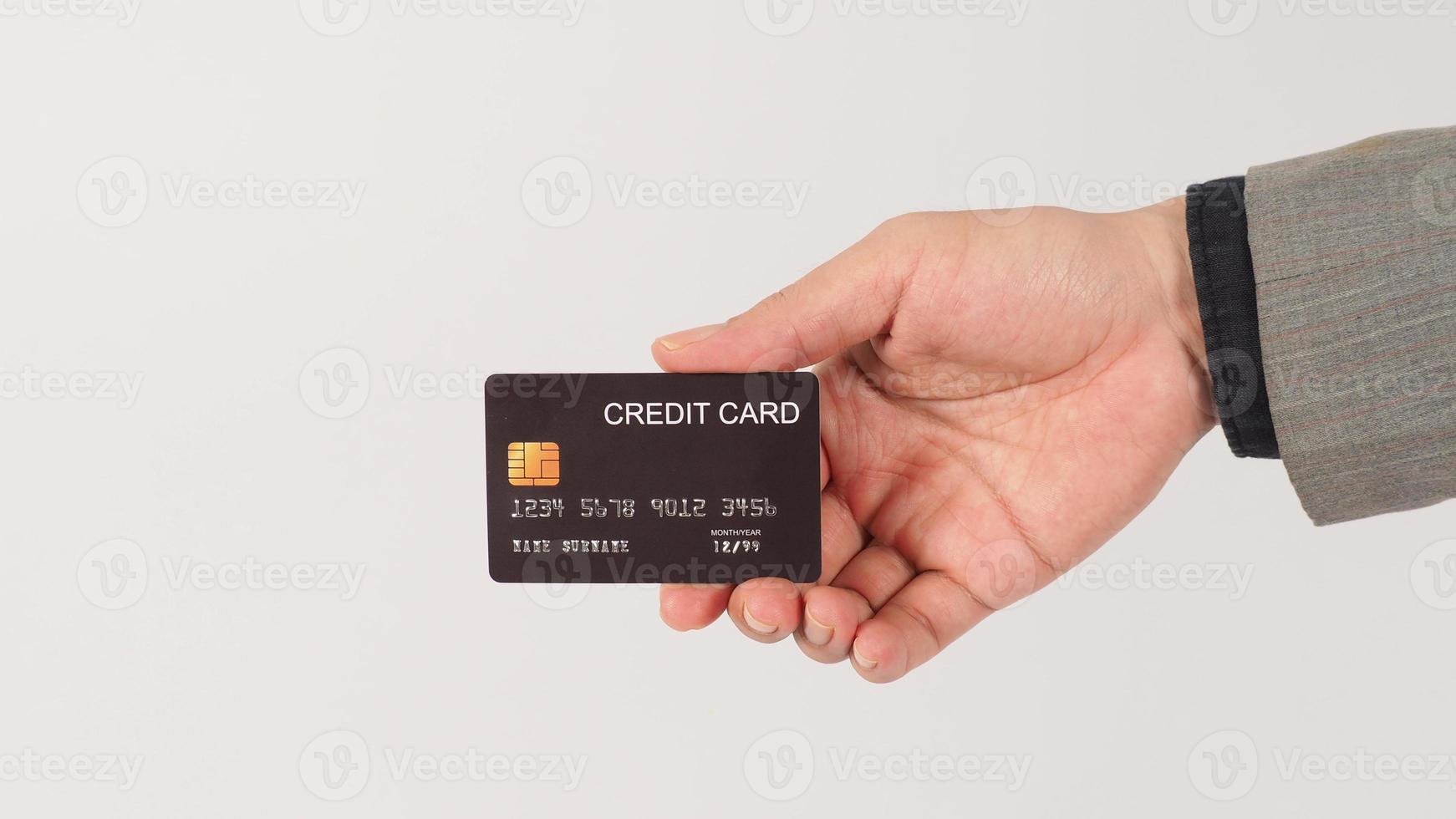 uma mão está segurando cartões de crédito pretos e vestindo terno em fundo branco. foto