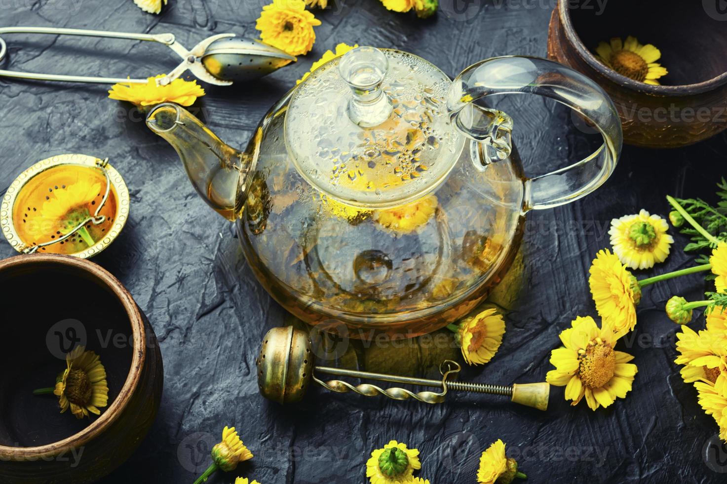 bule com chá de flores frescas, fitoterapia foto