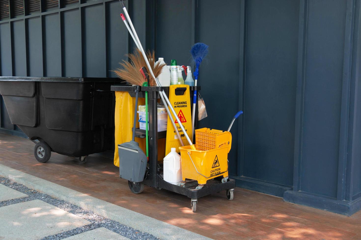 cartão jornitorial com parque de equipamentos de limpeza completo ao lado da parede escura no hotel foto