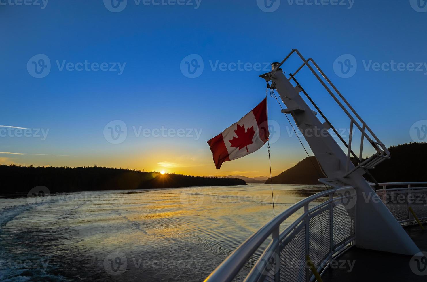 bandeira canadense em uma balsa ao pôr do sol foto