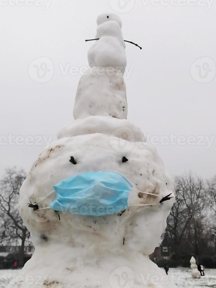 boneco de neve usando uma máscara de vírus corona foto