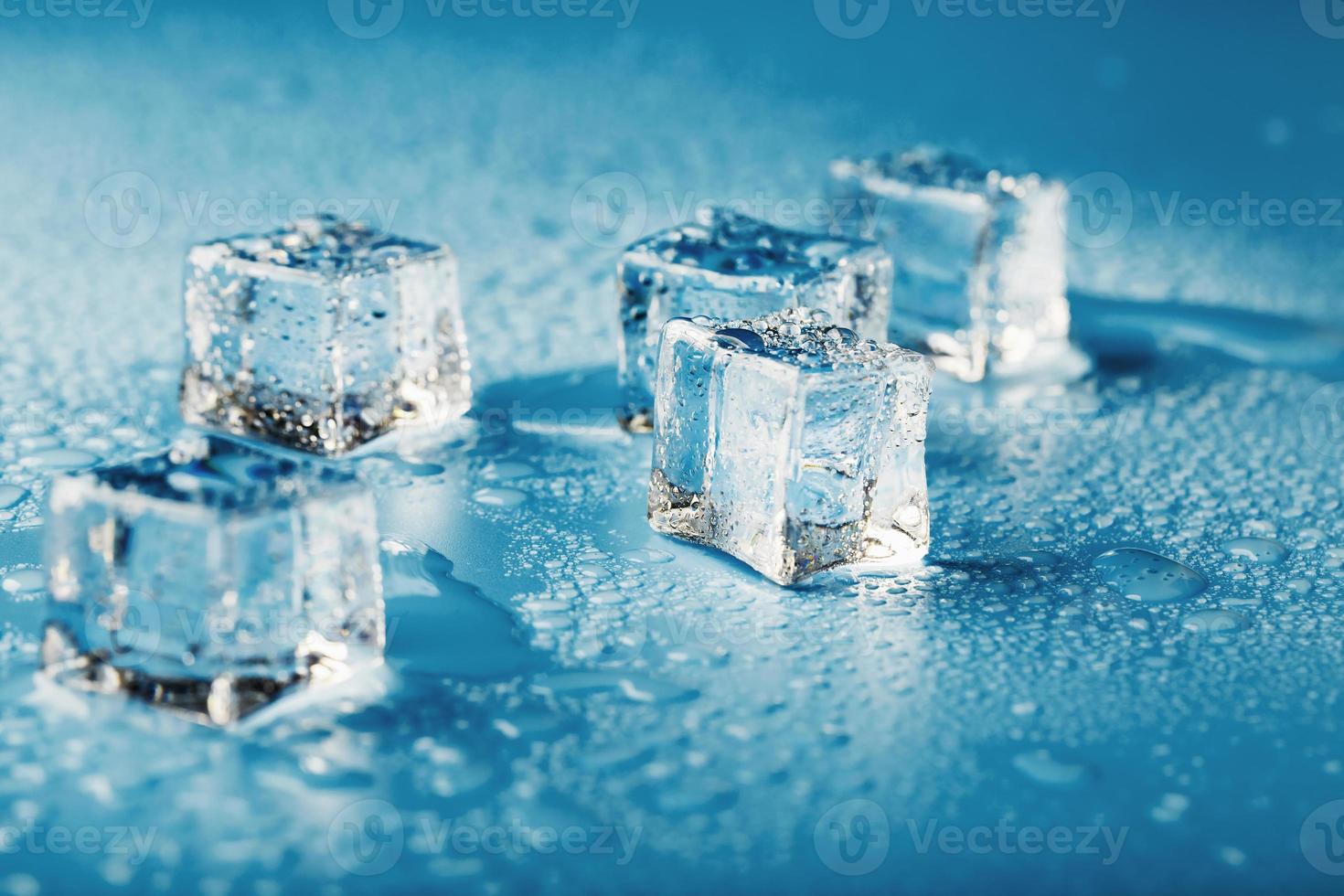 blocos de gelo com água cai close-up. cubo refrescante de gelo macro para uma bebida em um dia quente foto