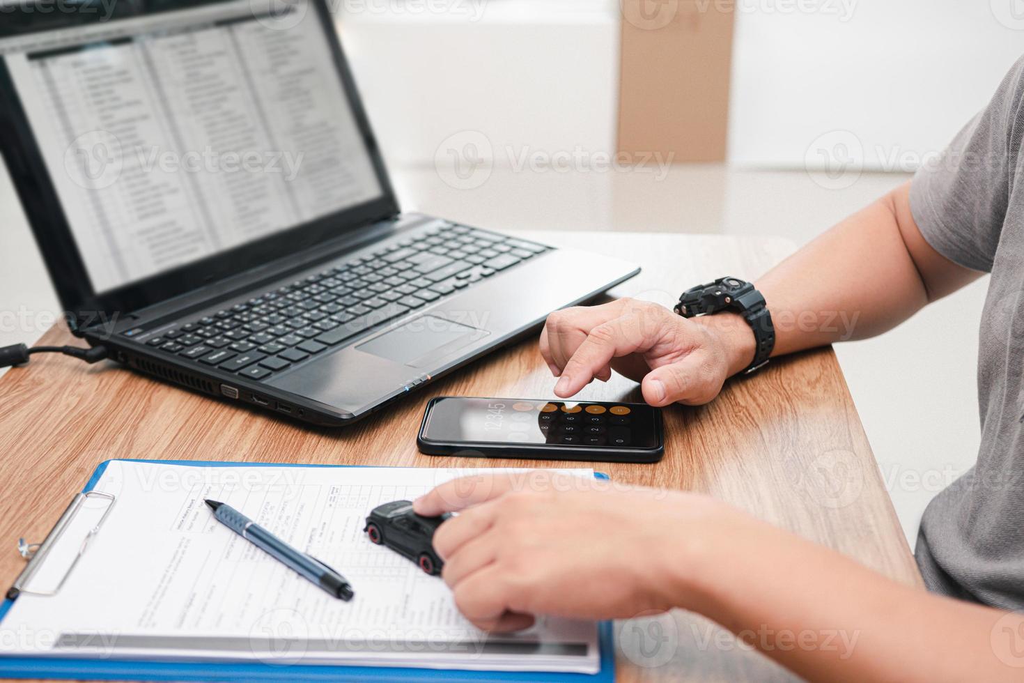 a equipe de serviço usa o smartphone para calcular o custo do reparo do carro a partir do documento de avaliação de danos e usar o laptop no centro de serviço do escritório de mesa foto