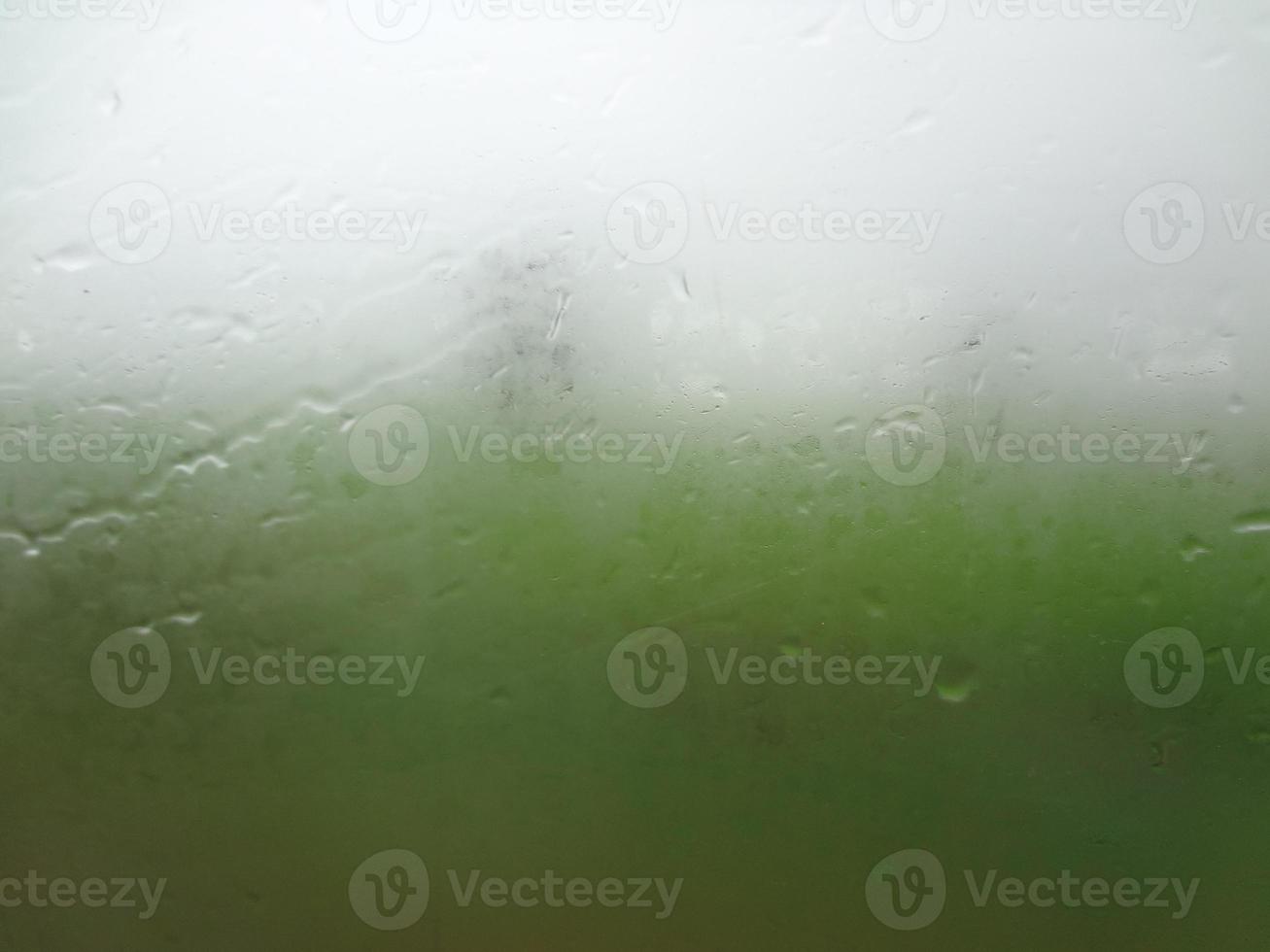 vidro de janela com alta umidade de condensação, gotas grandes fluem para baixo, fundo de gota de água natural verde. foto
