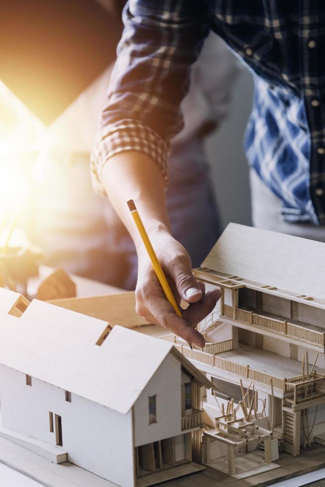 engenheiro de construção trabalhando na planta para construir grandes edifícios comerciais no escritório. ferramentas de engenharia e conceito de construção. foto