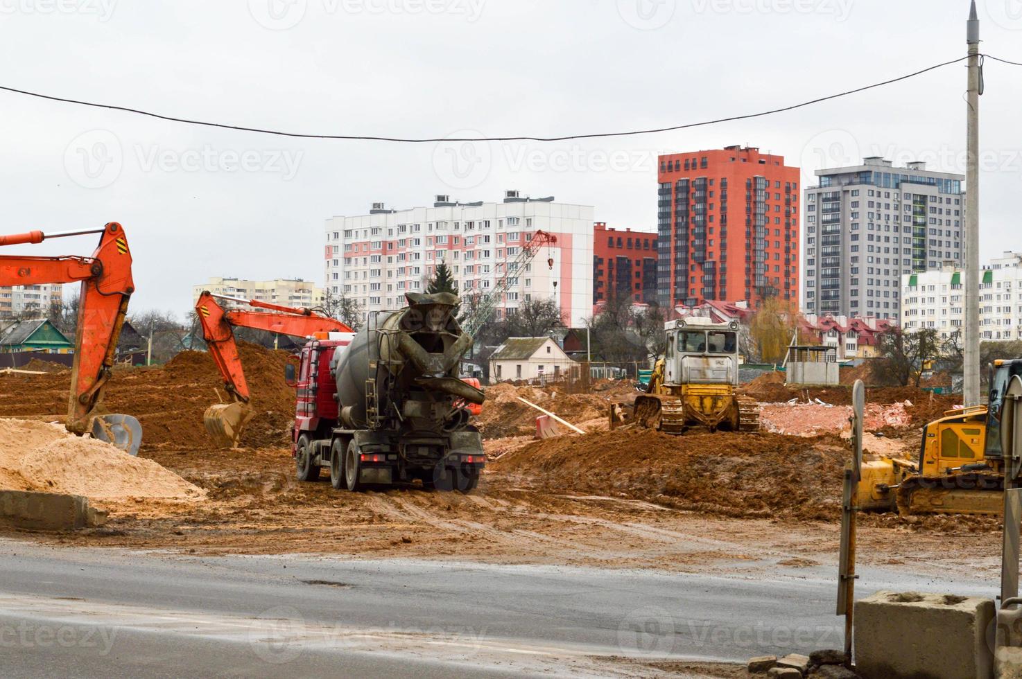 muitos poderosos equipamentos de construção industrial pesados especializados de escavadeiras e tratores fazem reparos de estradas durante a construção de um novo microdistrito em uma cidade grande foto