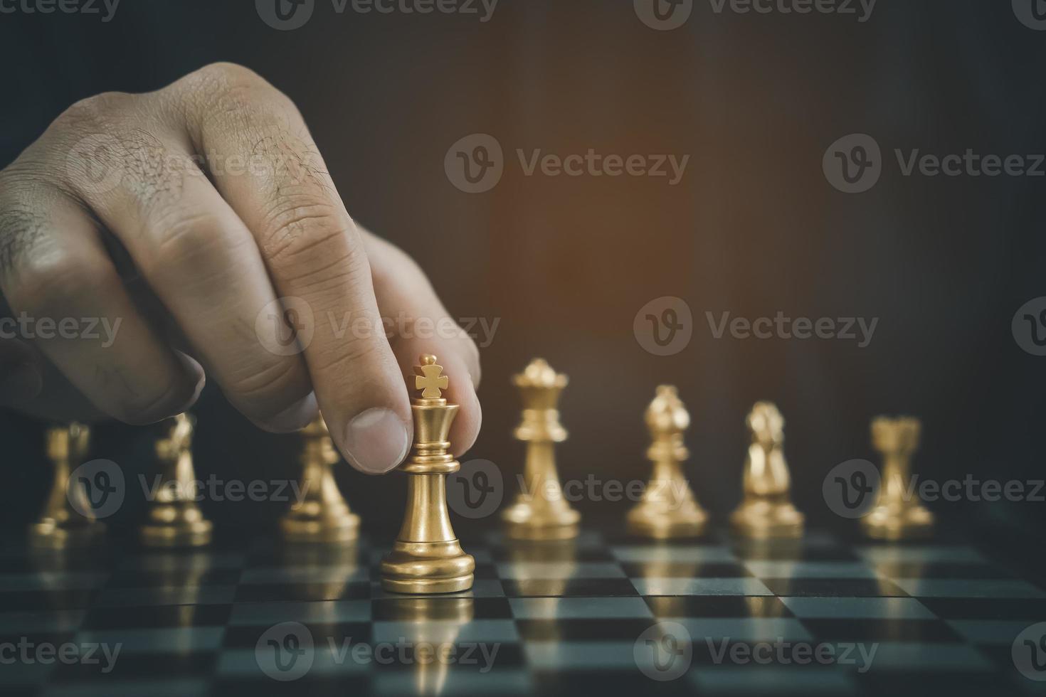 Empresário com as mãos em um terno preto sentado e apontando para o rei do  xadrez na mesa vintage significado de planejamento e estratégia