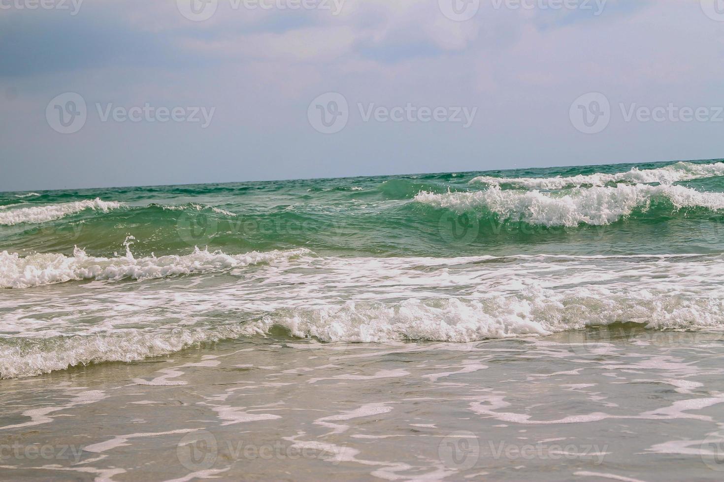 onda suave branca na praia tropical vazia e mar azul com céu azul foto