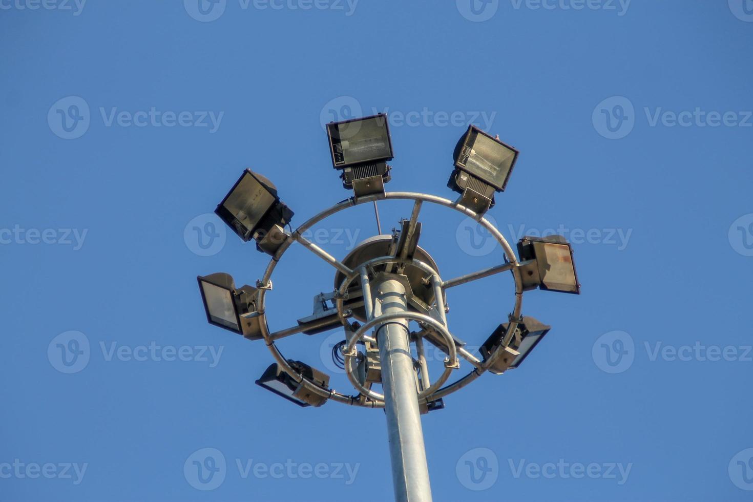 um grande poste elétrico cheio de holofotes no céu azul foto