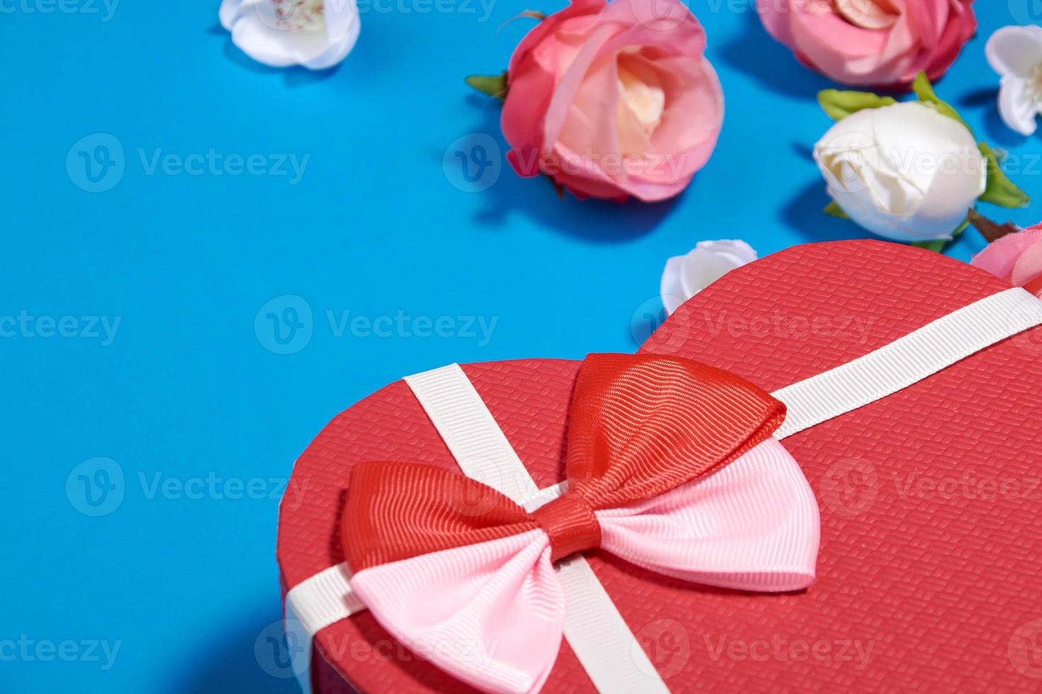 um cartão postal de uma caixa em forma de coração e rosebuds.valentine's day concept foto