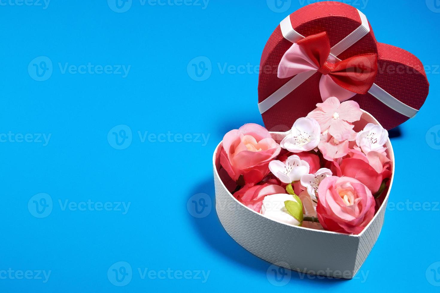 um cartão postal de uma caixa em forma de coração e rosebuds.valentine's day concept foto