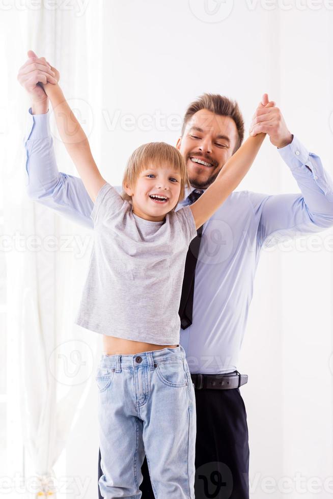 adoramos passar tempo juntos pai feliz em trajes formais se divertindo com seu filho em casa foto