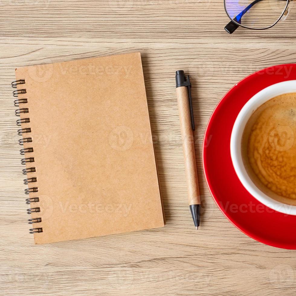 caderno em branco e xícara de café na mesa de madeira. motivação, resolução, lista de tarefas, estratégia e conceito de plano foto