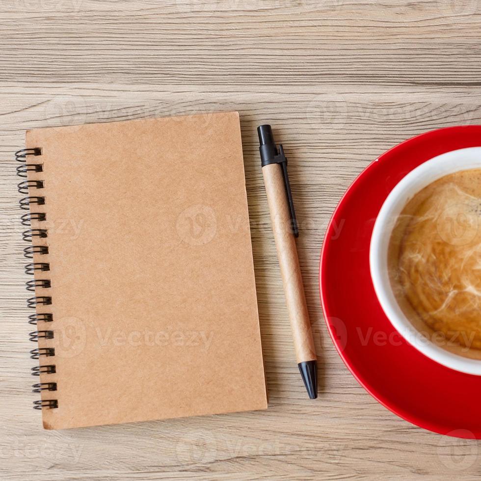 caderno em branco e xícara de café na mesa de madeira. motivação, resolução, lista de tarefas, estratégia e conceito de plano foto