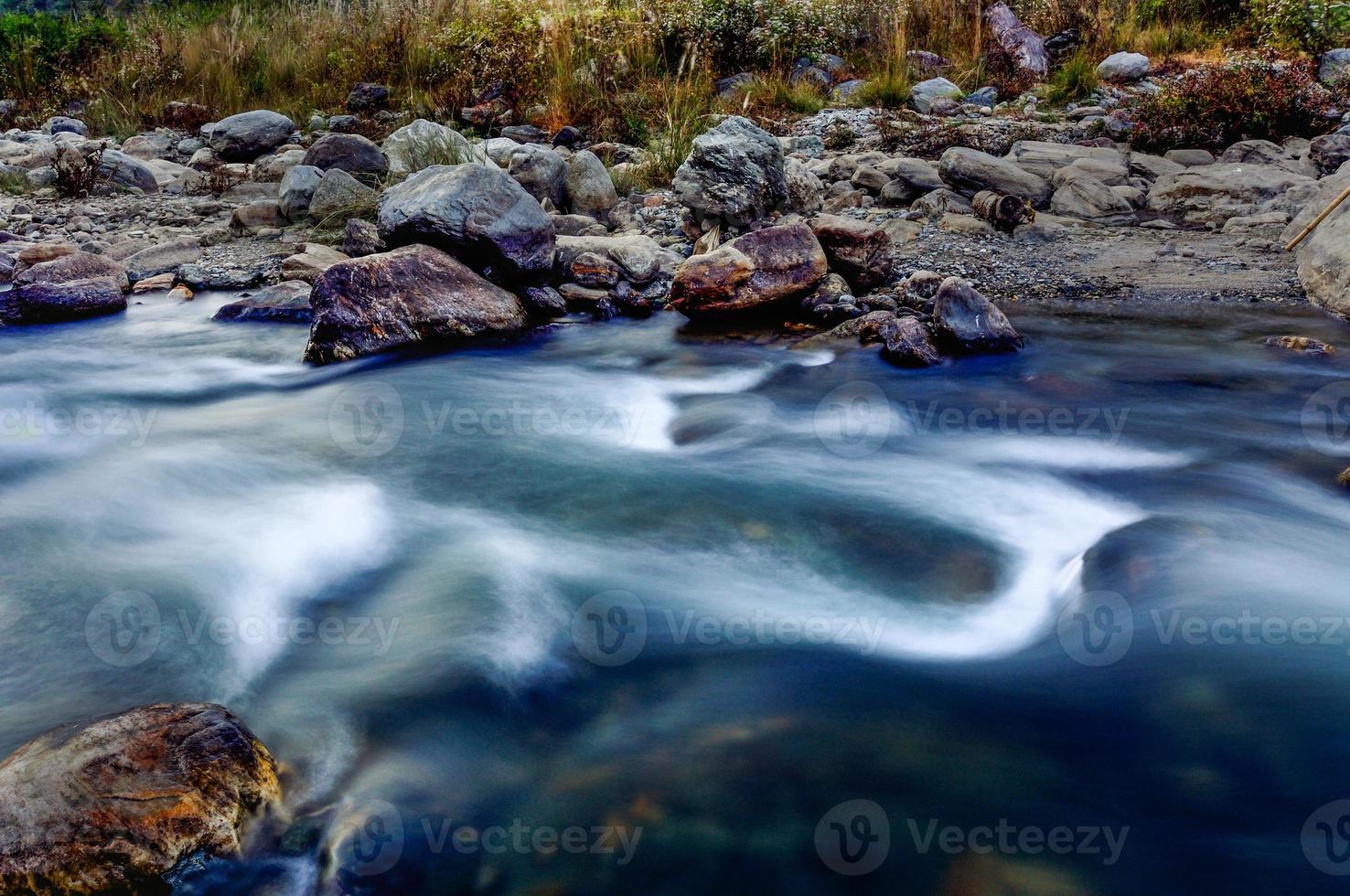 água do rio fluindo através das rochas ao entardecer, sikkim, índia foto