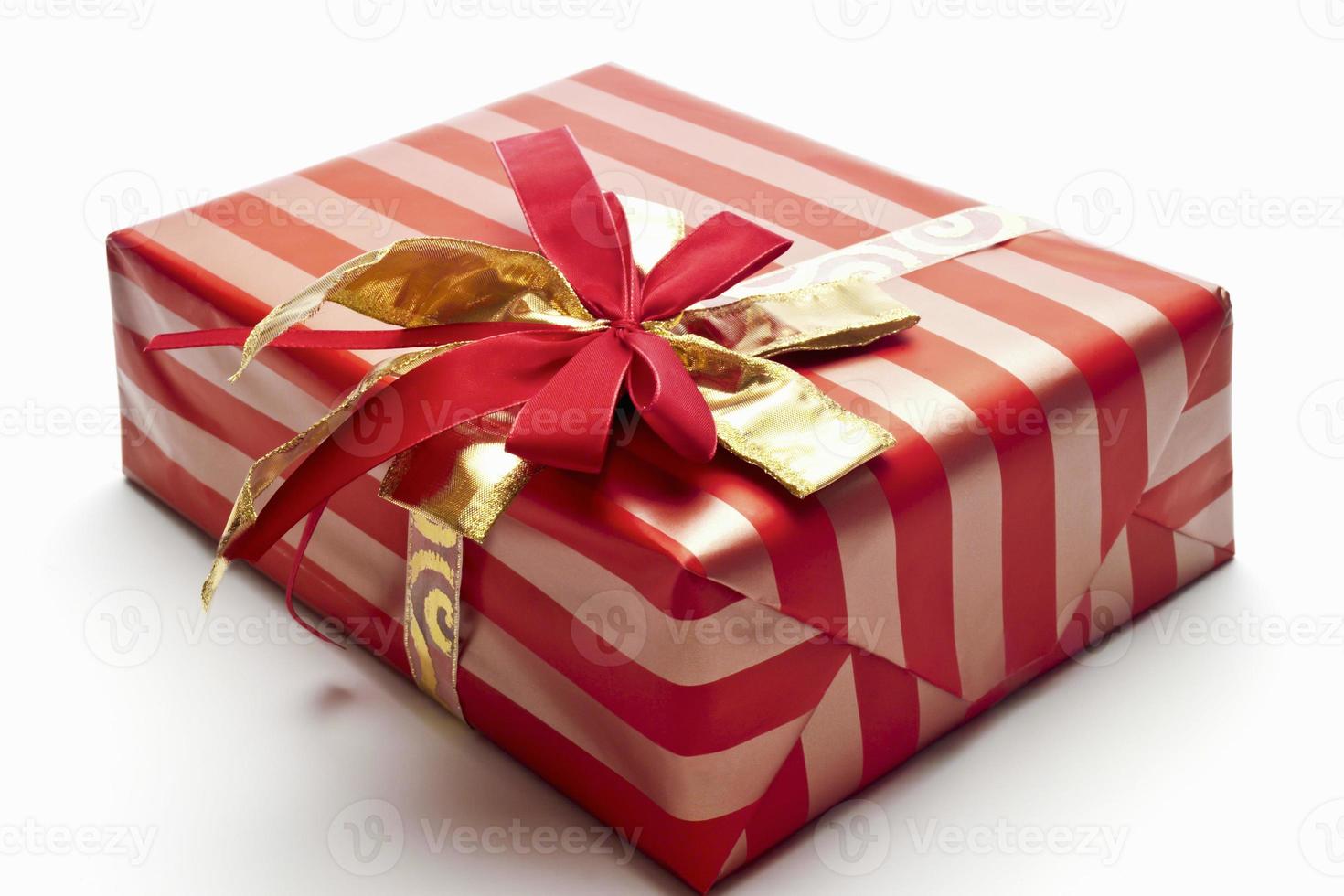 pacote de natal com fita vermelha e dourada foto