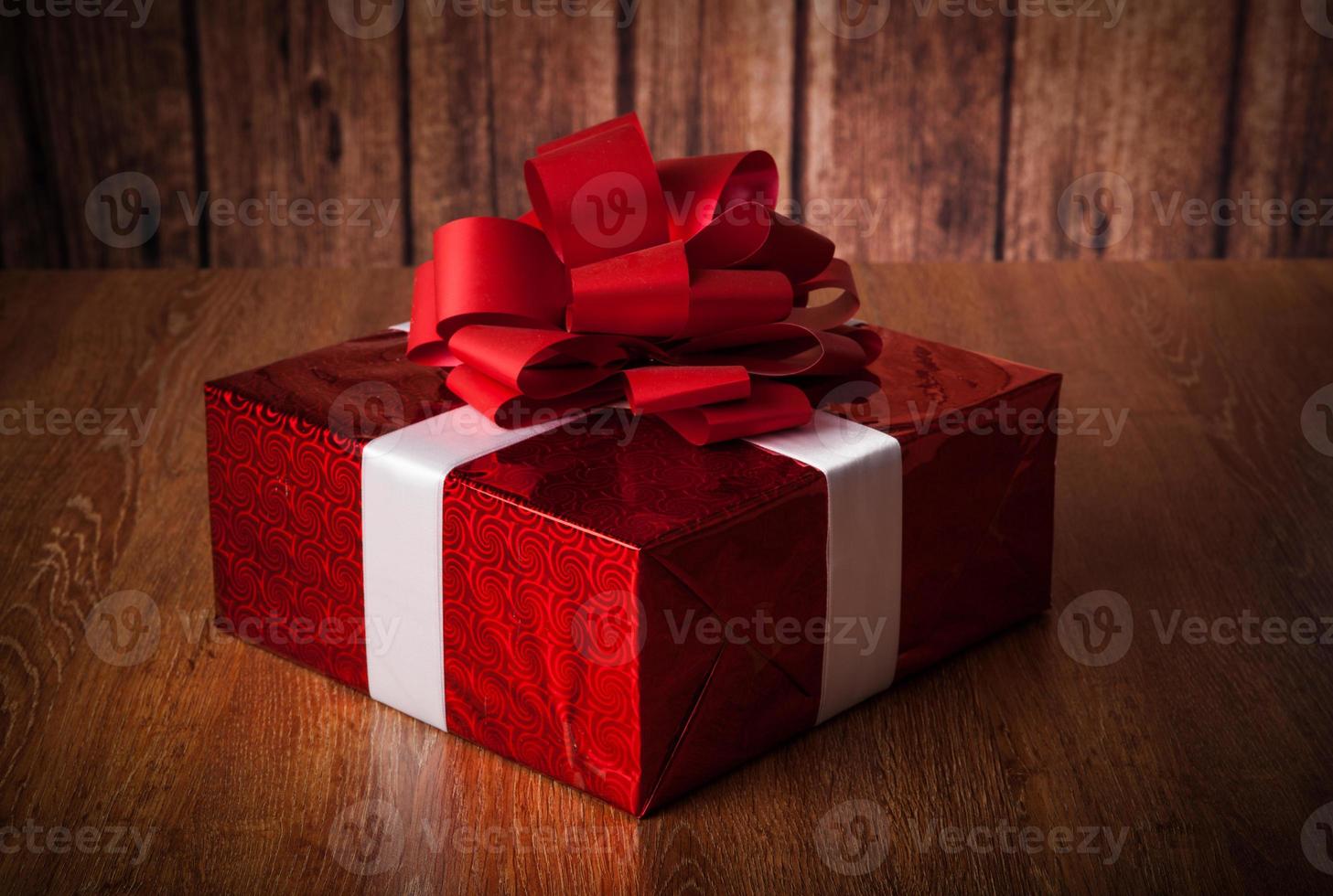 uma grande caixa de presente vermelha em uma madeira foto