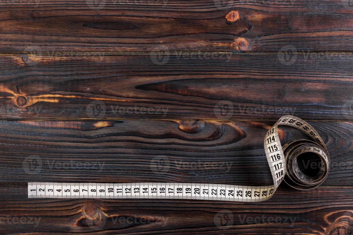medidor de alfaiataria e tesoura no antigo fundo de madeira foto