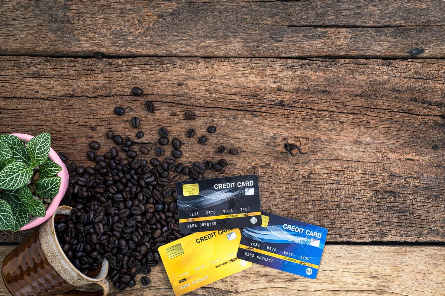cartões de crédito e grãos de café na mesa, vista de cima foto
