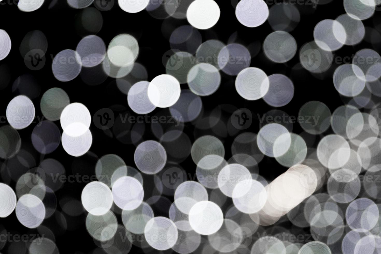 bokeh abstrato de luzes da cidade branca sobre fundo preto. desfocado e desfocado muitas luzes redondas foto