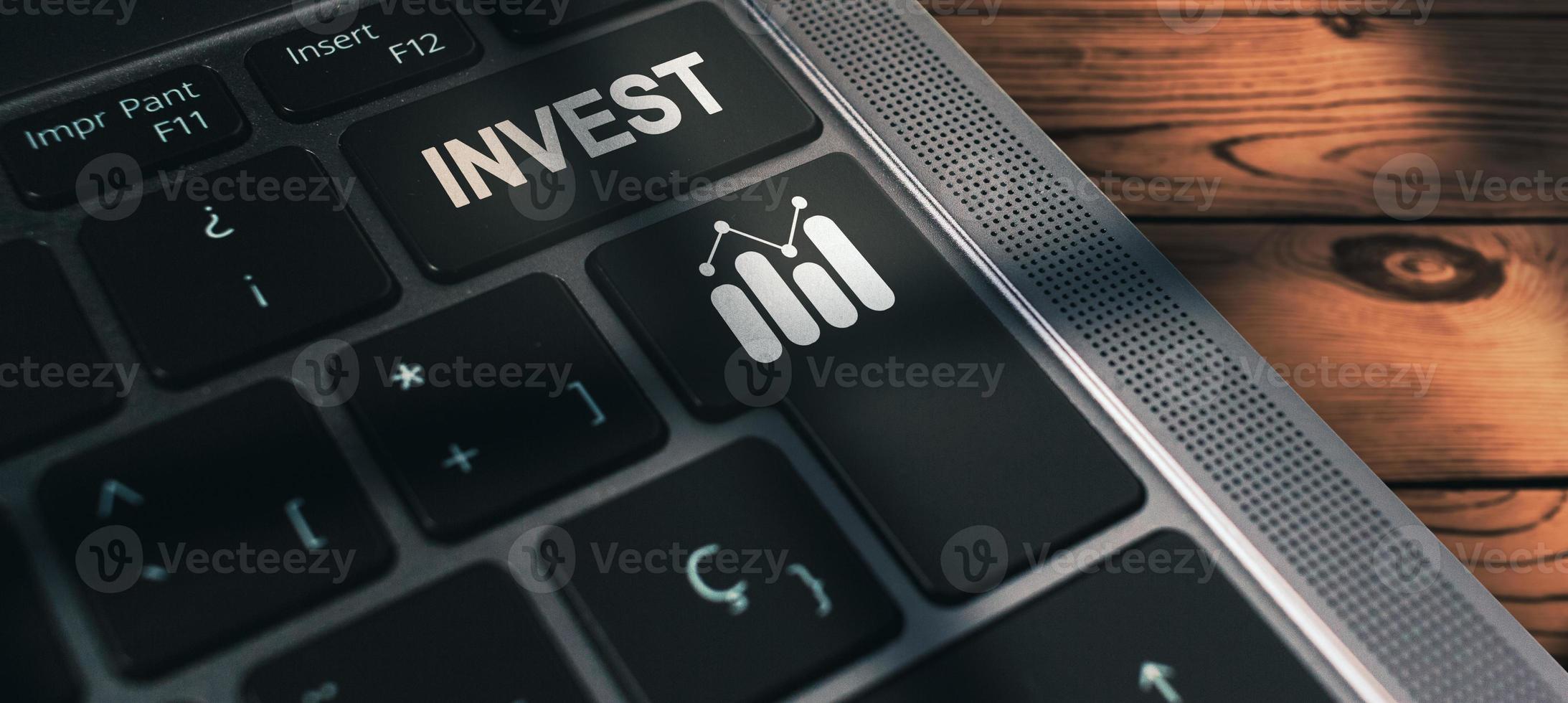 banner do teclado do laptop com a palavra de investimento no botão. fundos de investimento na bolsa de valores e ativos digitais. tecnologia de finanças de negócios e conceito de investimento. foto