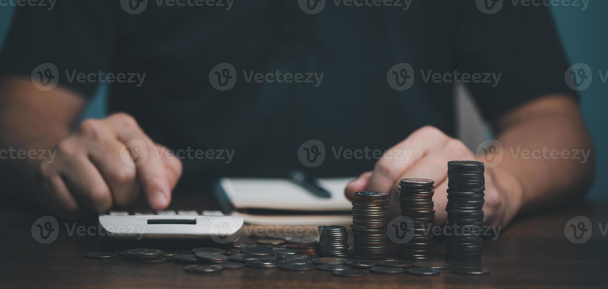 mão de homem segurando a moeda de dinheiro na mesa de madeira, economizando dinheiro riqueza e conceito financeiro, negócios, finanças, investimento, planejamento financeiro. foto