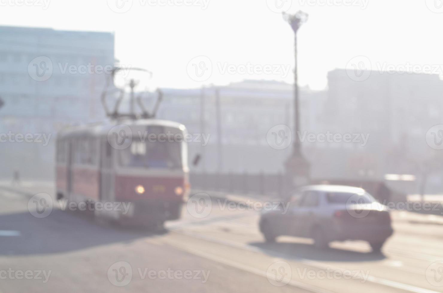 paisagem borrada da estrada com carros e bonde na manhã de neblina foto