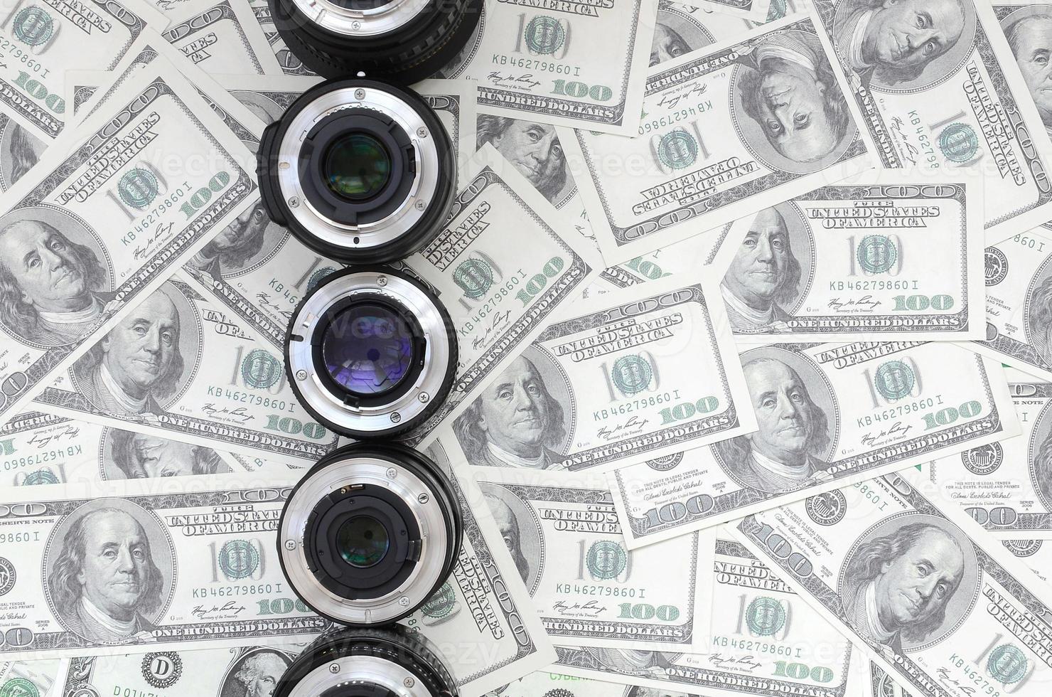 algumas lentes fotográficas estão no fundo de muitas notas de dólar. espaço para texto foto