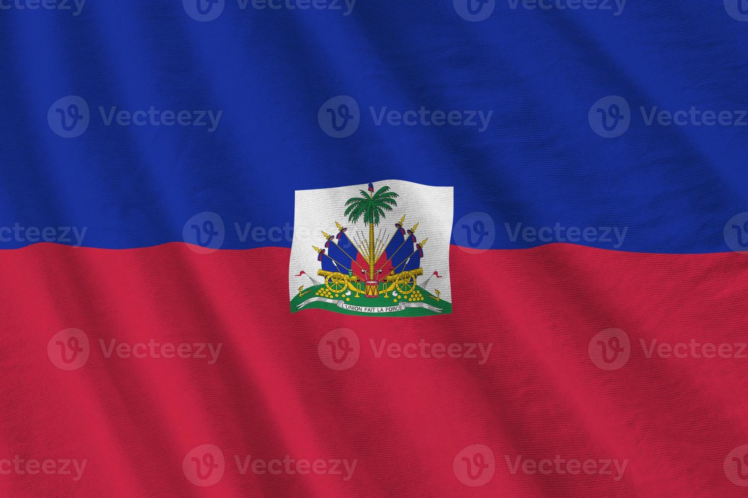 bandeira do haiti com grandes dobras acenando de perto sob a luz do estúdio dentro de casa. os símbolos oficiais e cores no banner foto