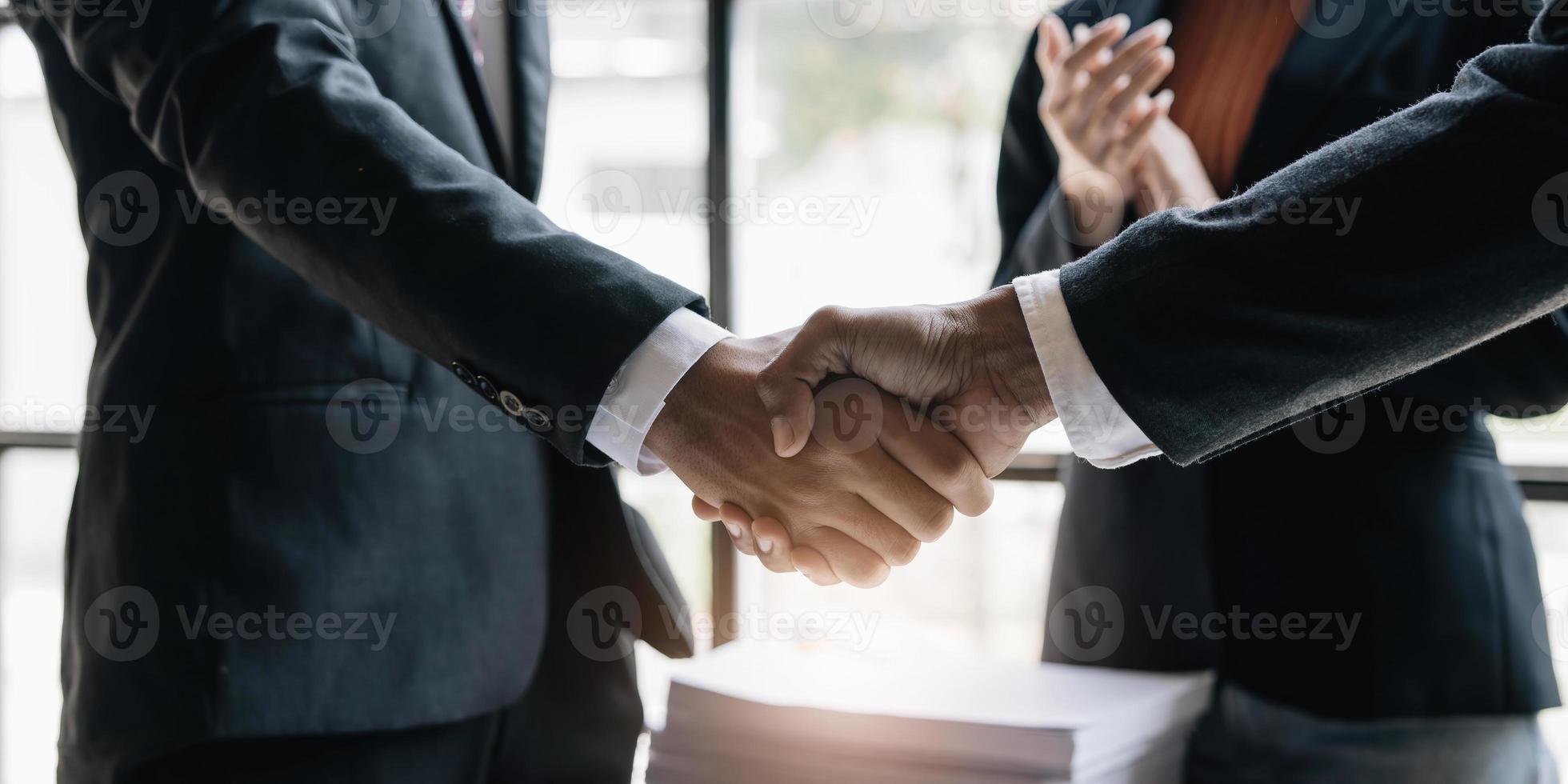 empresários apertando as mãos, terminando a reunião, etiqueta empresarial, parabéns, conceito de fusão e aquisição foto