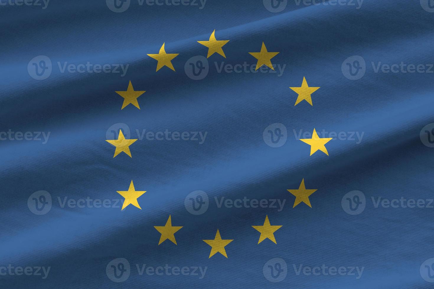 bandeira da união europeia com grandes dobras acenando de perto sob a luz do estúdio dentro de casa. os símbolos oficiais e cores no banner foto