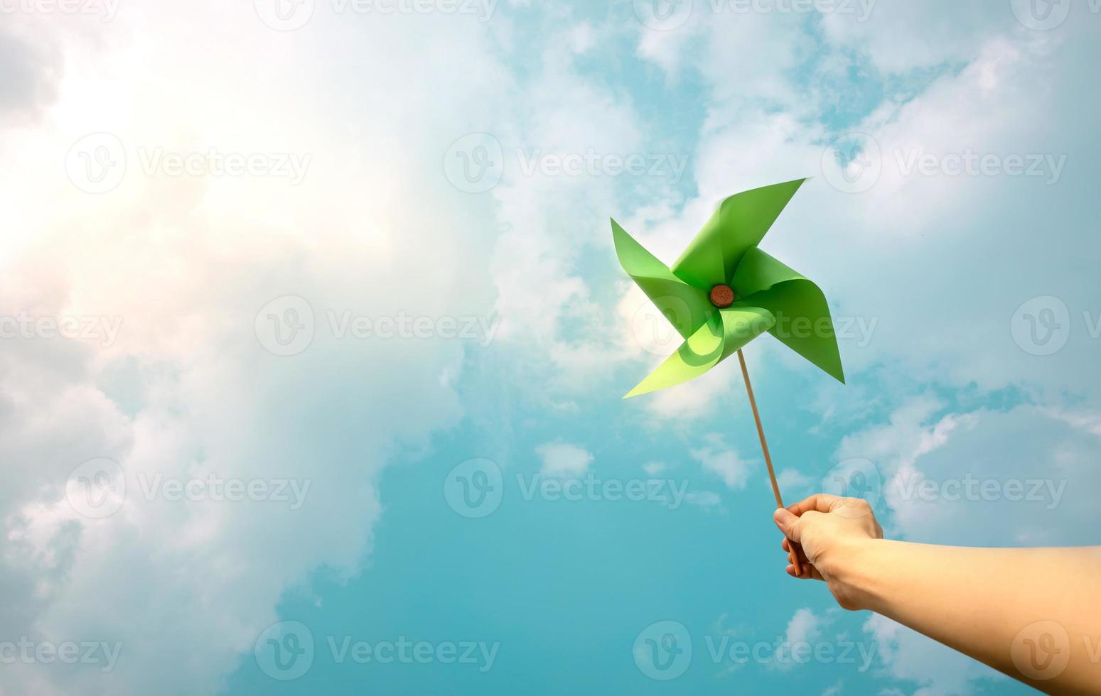 esg e conceito de energia limpa. mão levante um papel de turbina eólica para o céu. diminuir o carbono e produzir uma energia verde. dia mundial da terra, recursos sustentáveis, cuidado com o meio ambiente foto