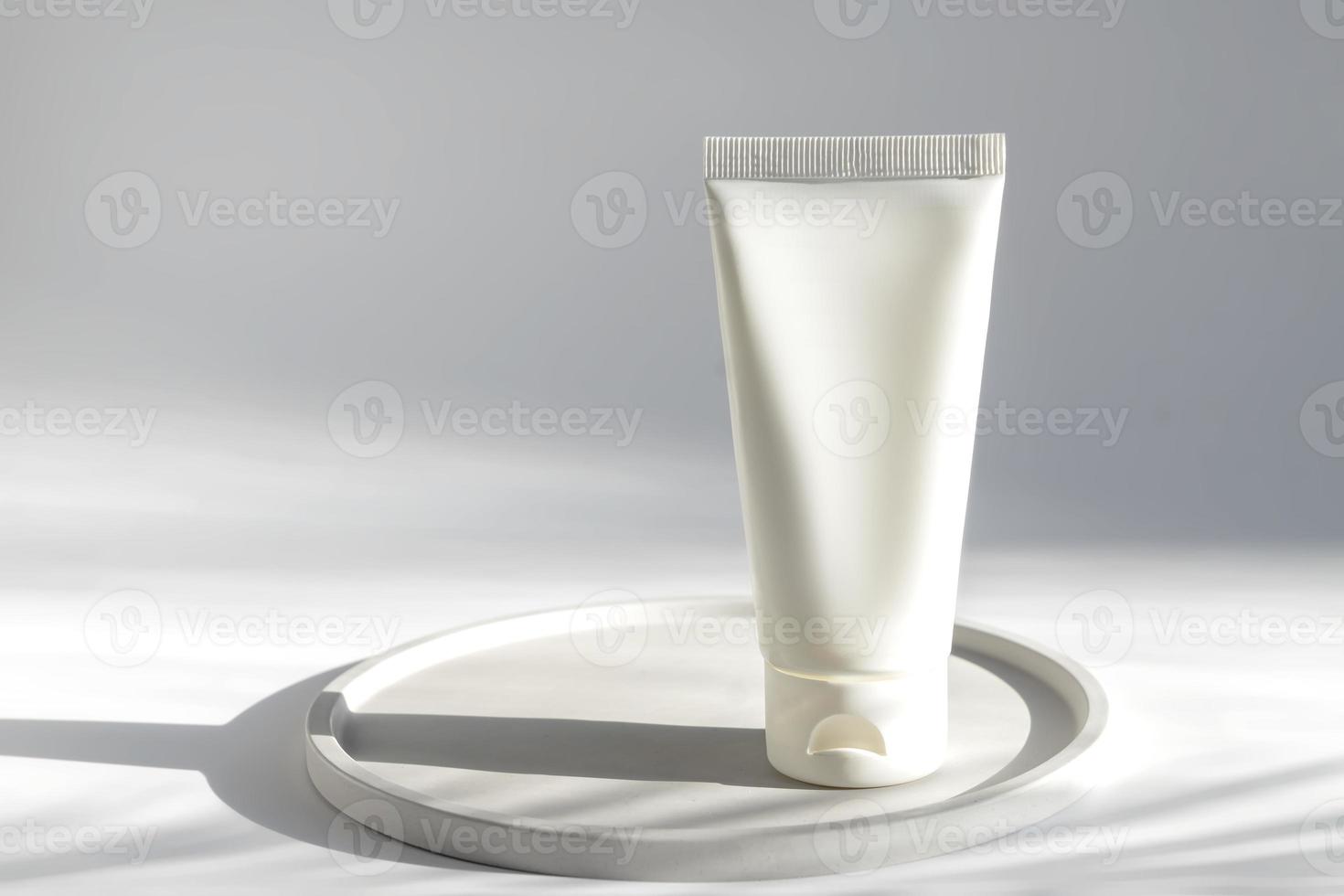 frasco de creme cosmético de aperto branco sem marca. tubo branco de plástico para creme facial ou loção. cuidados com a pele ou protetor solar cosmético foto