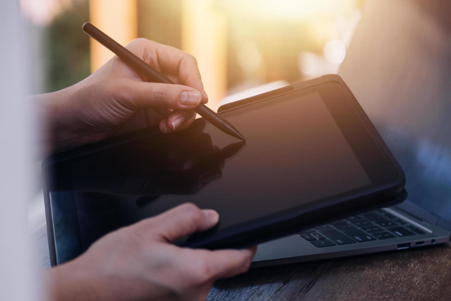 mão de empresária trabalhando com computador portátil, tablet e telefone inteligente no escritório moderno com diagrama de ícone virtual no modernoffice na luz da manhã foto