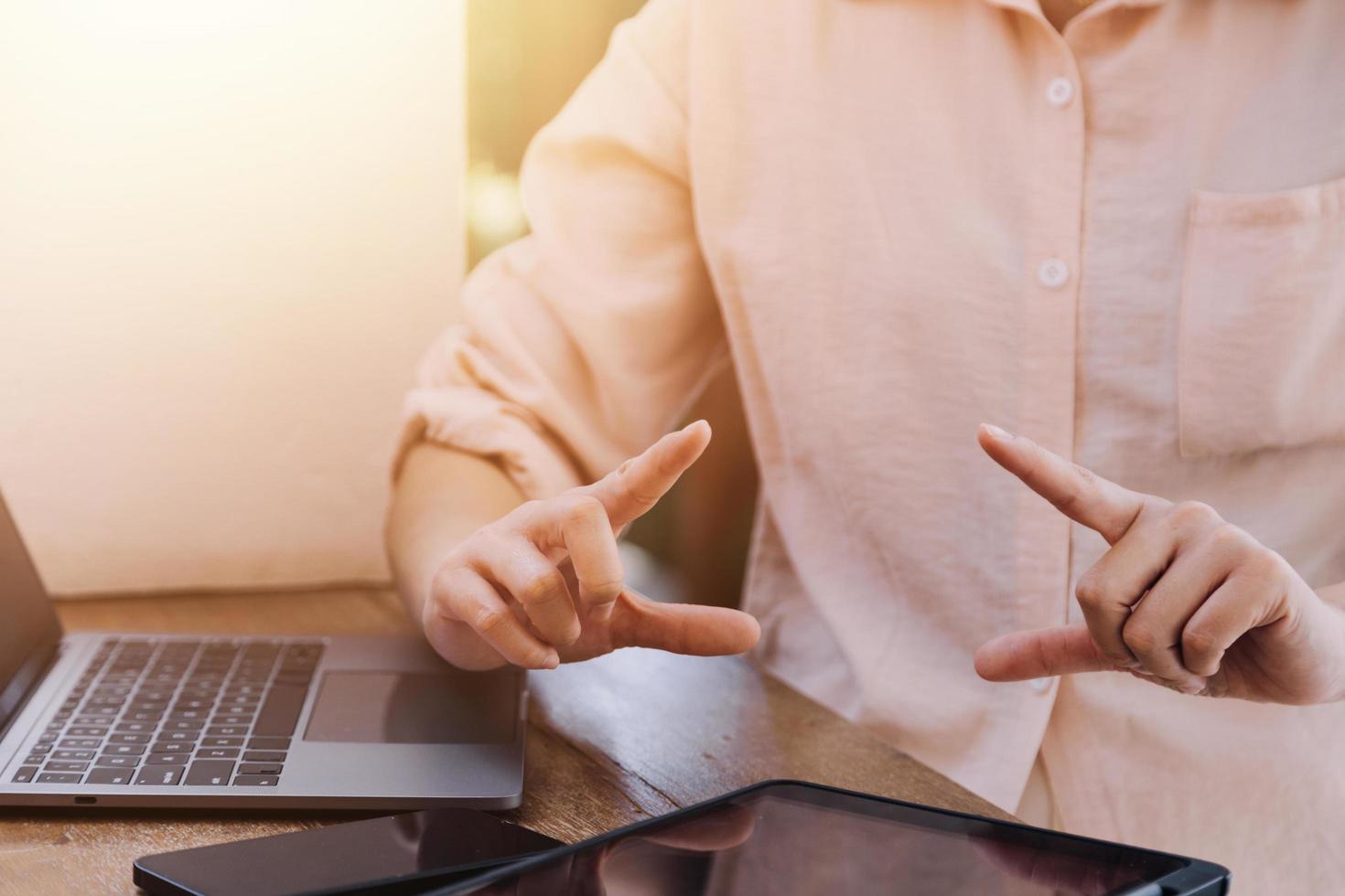 mão de empresária trabalhando com computador portátil, tablet e telefone inteligente no escritório moderno com diagrama de ícone virtual no modernoffice na luz da manhã foto