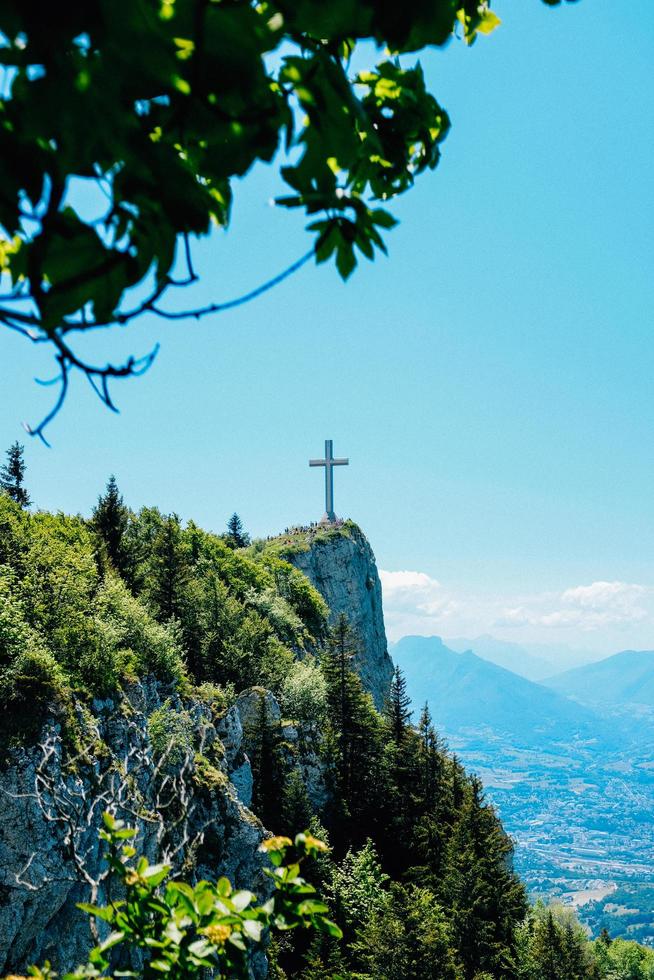 árvores verdes na montanha com cruz foto