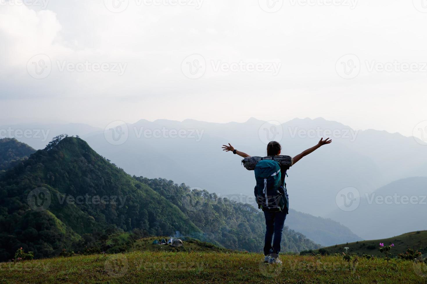 mulher jovem viajante com mochila elegante olhando para a incrível vista para as montanhas. curtindo a natureza, relaxe, prazer. foto