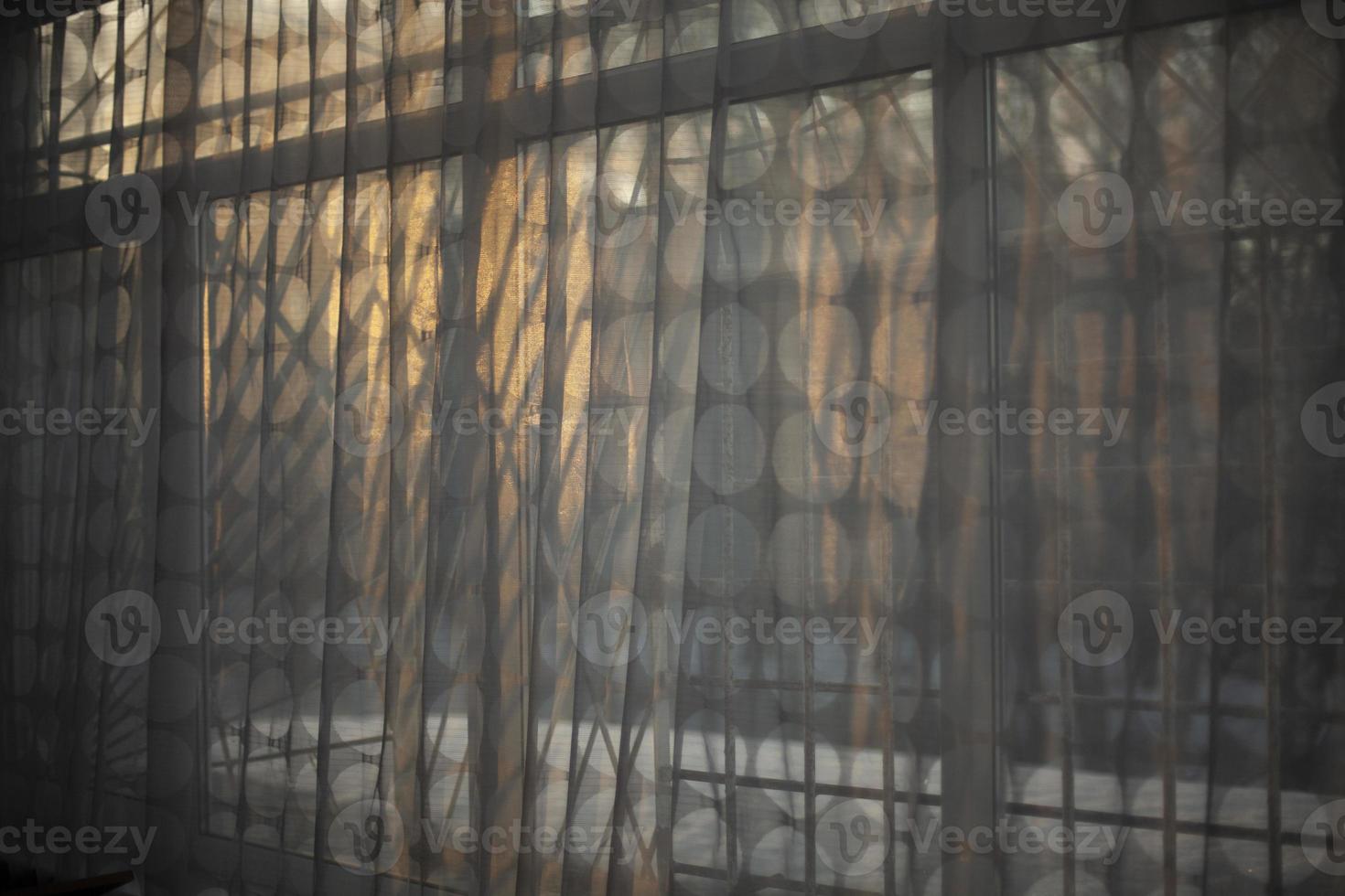 cortinas na janela à luz do sol. tule transparente fecha a janela. luz da noite no interior. foto