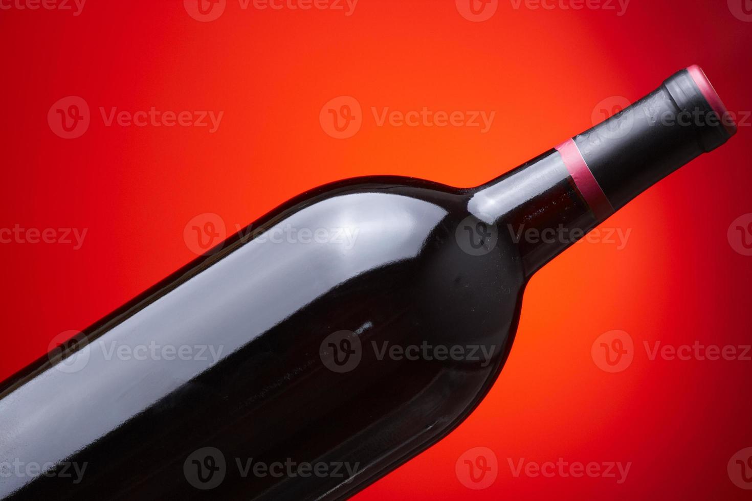 closeup de uma garrafa de vinho em um fundo vermelho foto