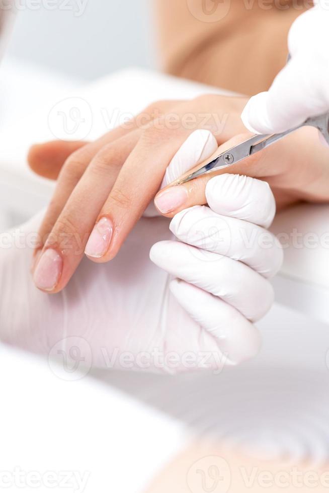 close-up de manicure usando uma tesoura de manicure foto