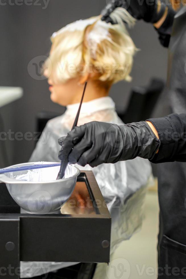 cabeleireiro tingindo o cabelo da jovem foto