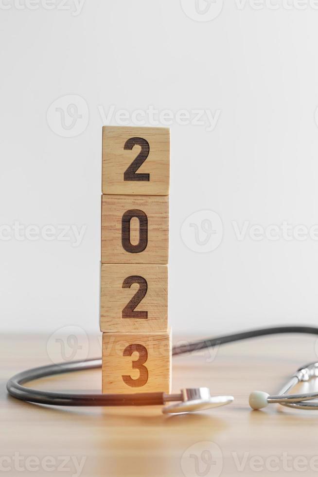 2023 feliz ano novo para cuidados de saúde, seguros, bem-estar e conceito médico. estetoscópio de médico na mesa foto