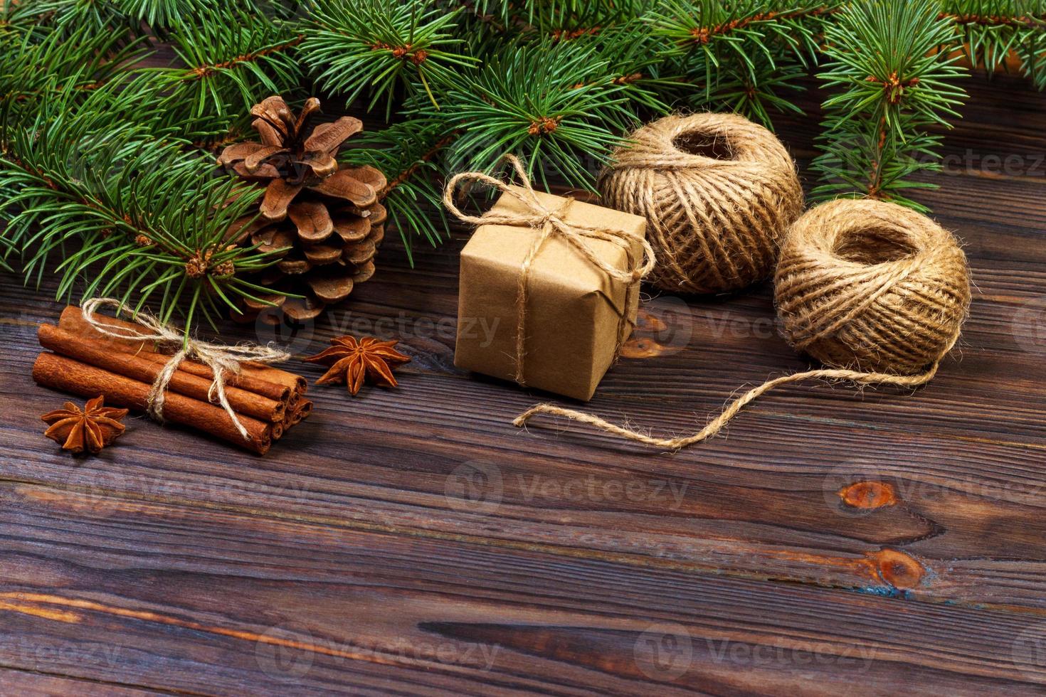 caixa de presente de natal. ramos de abeto com canela e anis em fundo de madeira rústico. postura plana. conceito de saudações sazonais. conceito de férias de inverno foto