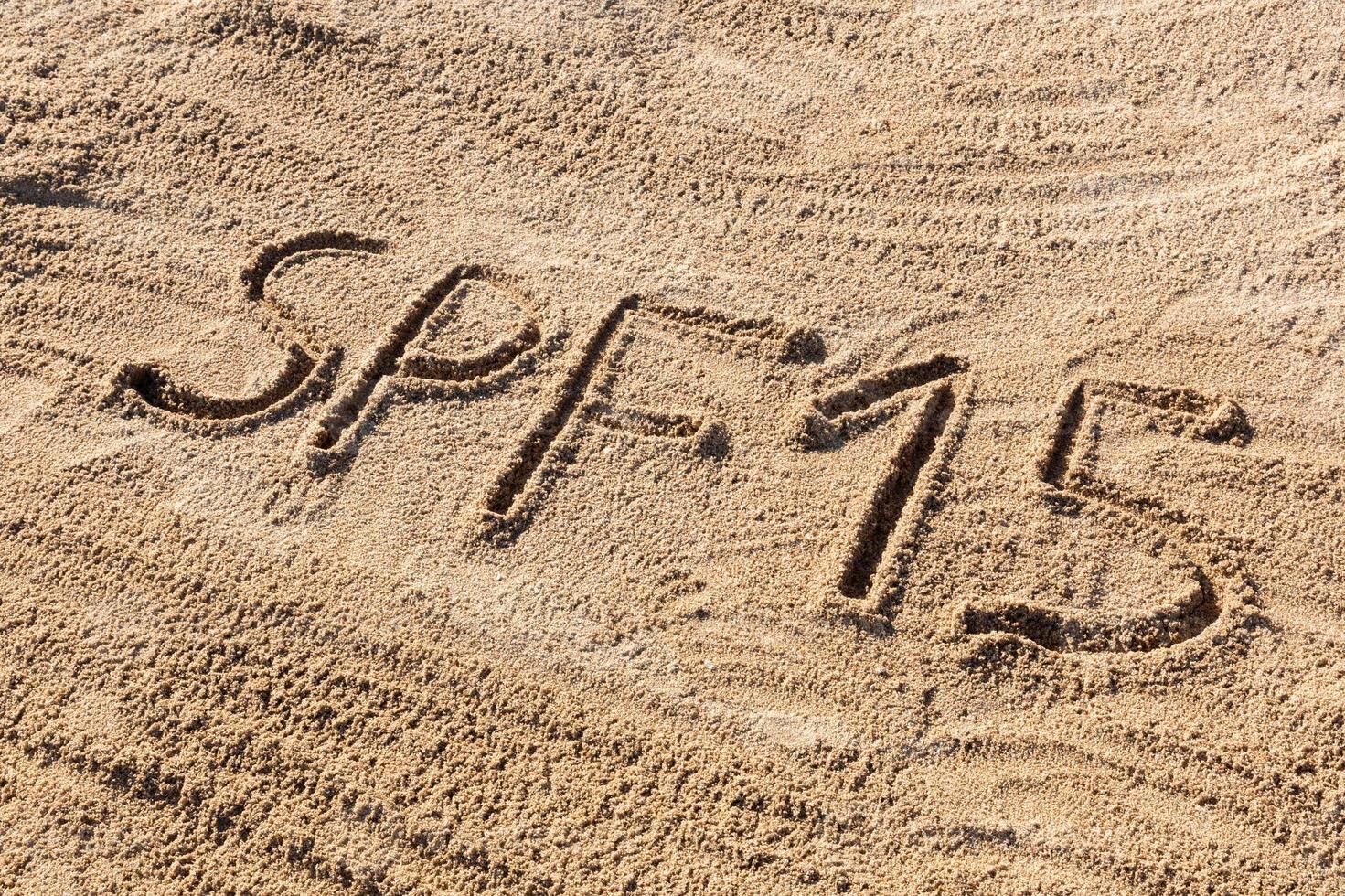 conceito de fator quinze de proteção solar. spf 10 palavra escrita na praia foto