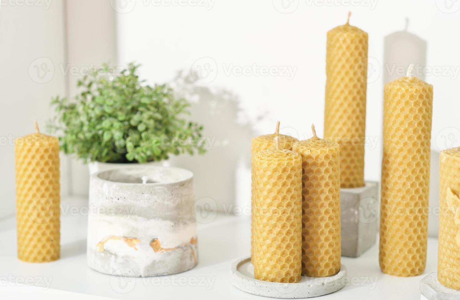 velas de cera de abelha para decoração de casa em uma prateleira com vasos de  flores de concreto. velas artesanais feitas de cera natural com fragrância  de mel. 13851795 Foto de stock