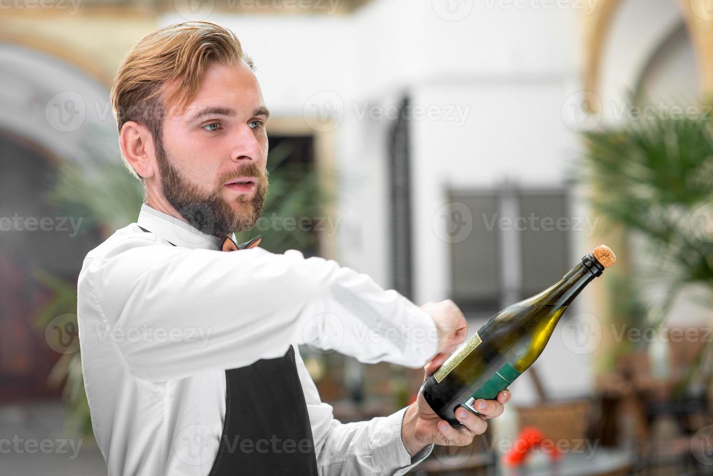 barman abrindo garrafa com espumante foto