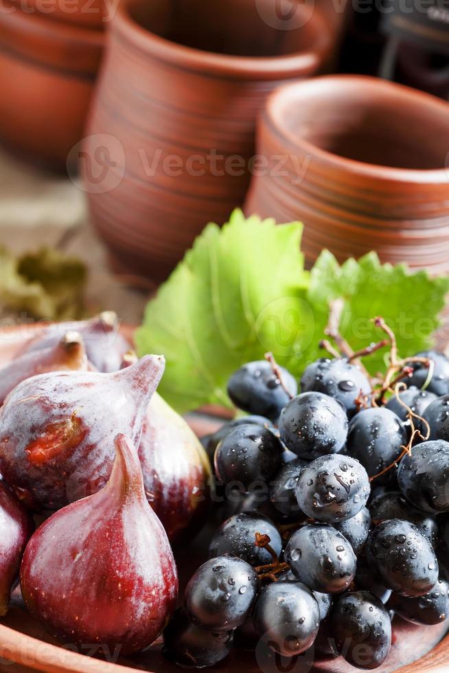 figos e uvas maduros em um prato de barro foto