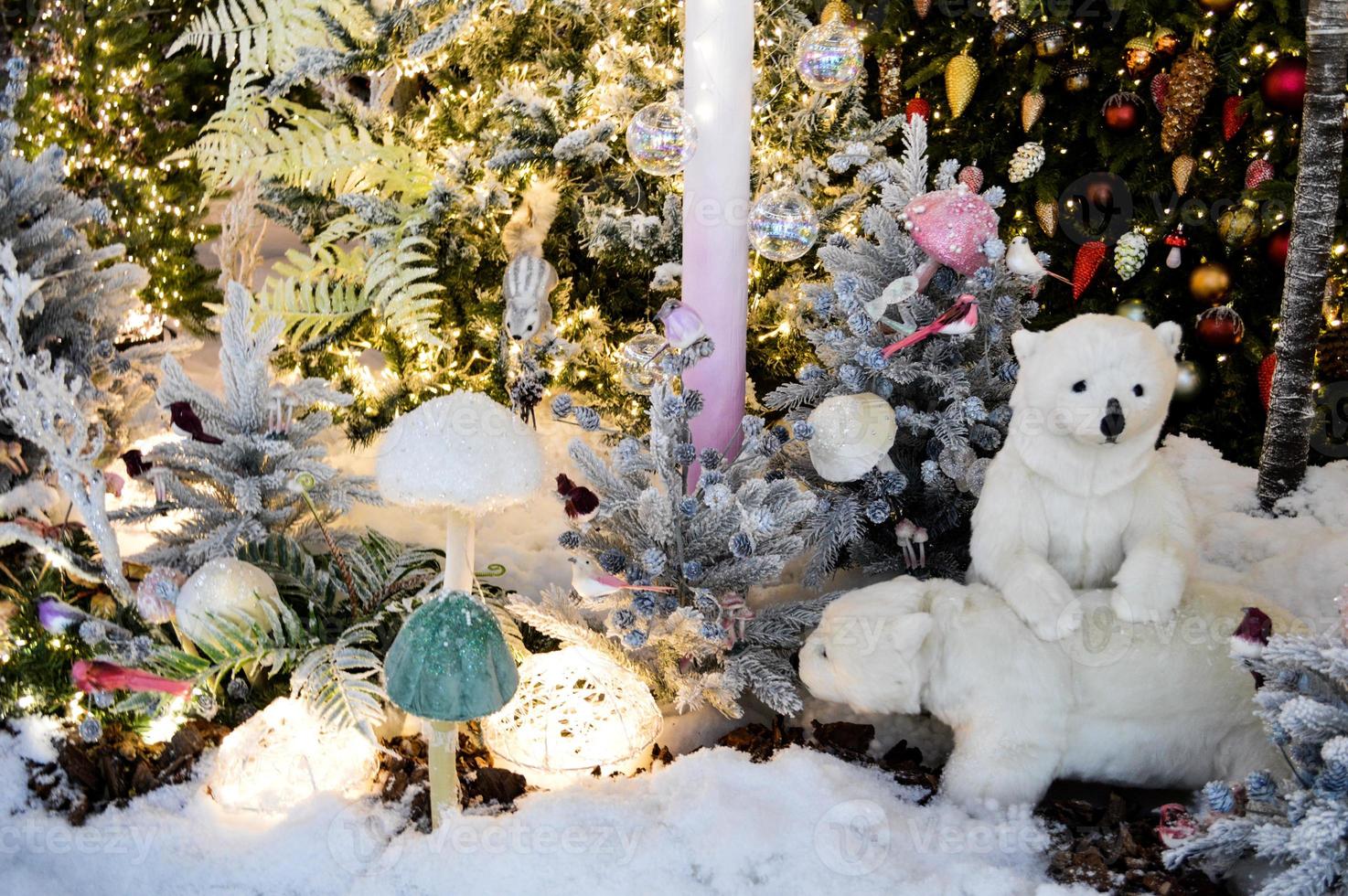 decoração de vitrine, decoração de shopping center. abeto branco artificial com guirlandas. ao lado deles estão dois filhotes de urso polar. cogumelos porcini artificiais na floresta foto