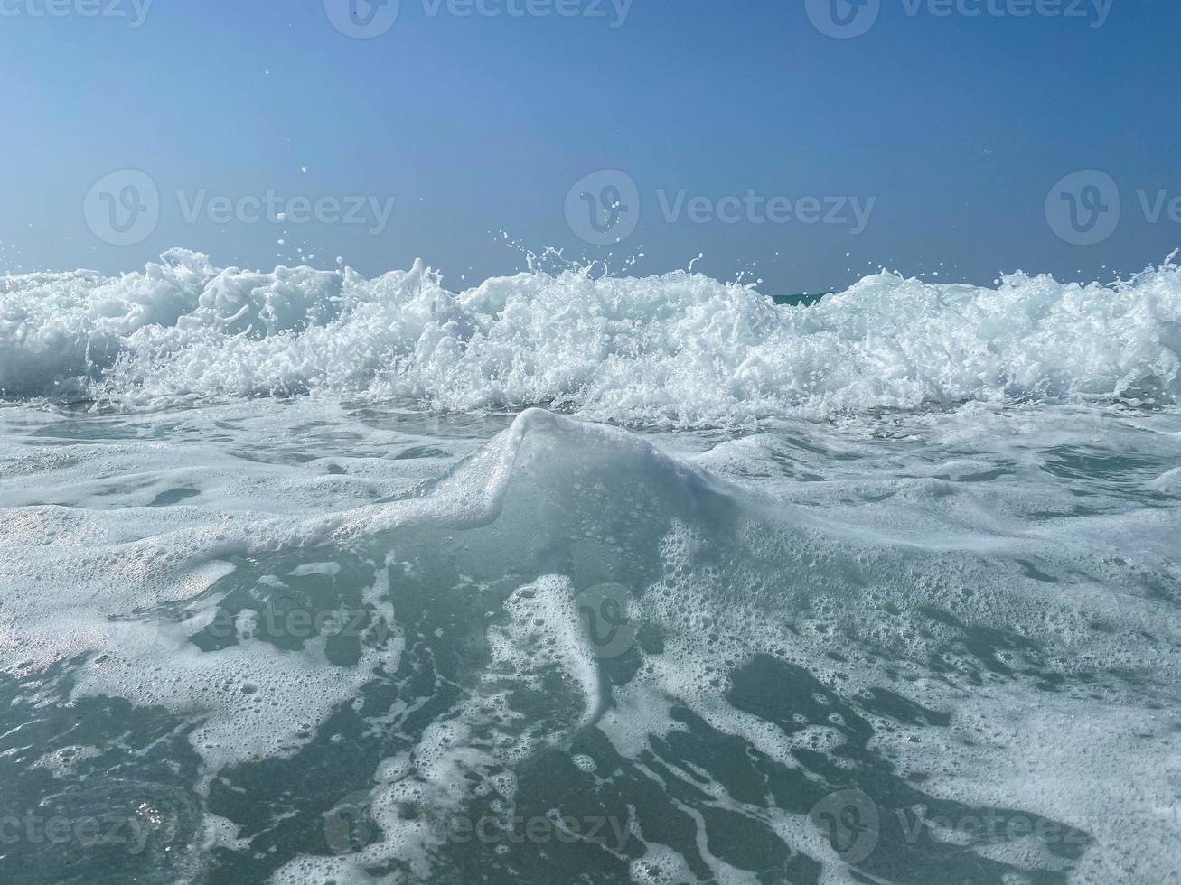 belo mar com ondas espirrando água azul clara e morna em um resort do sul do país oriental tropical quente. fundo, textura foto