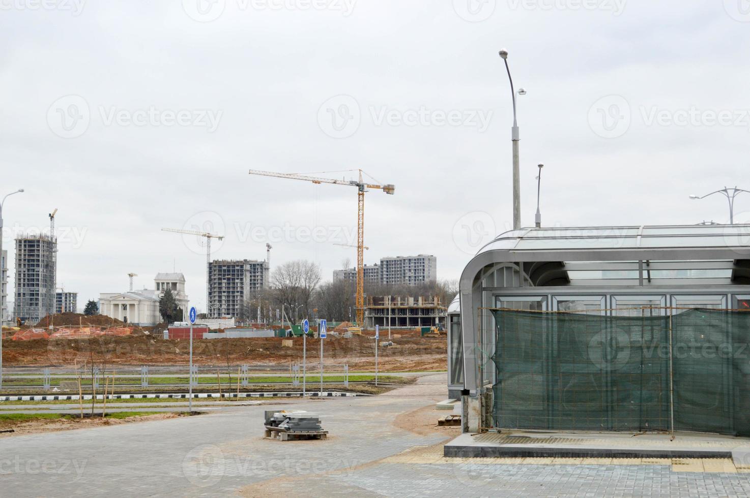 construção de um novo microdistrito com casas altas, novos prédios com infraestrutura desenvolvida com a ajuda de grandes guindastes industriais e equipamentos profissionais de construção em uma grande cidade foto